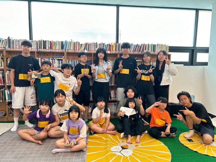 수만세 참여자들간 단체사진. 어린이와 청소년이 함께 놀이방에서 브이를 하고있다.
